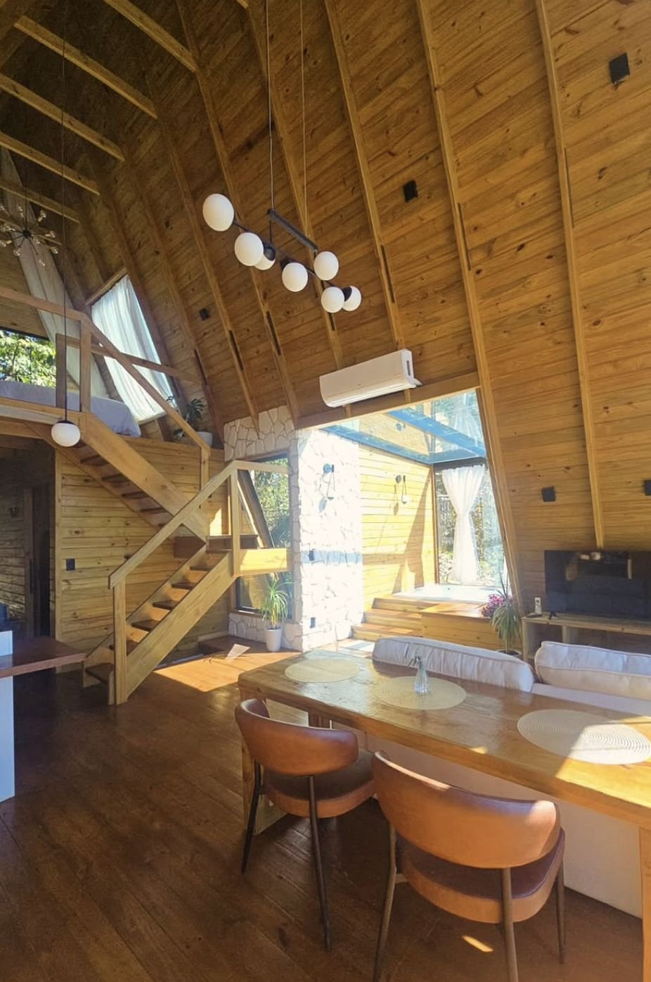 Sala com mesa de jantar e escada para o mezanino