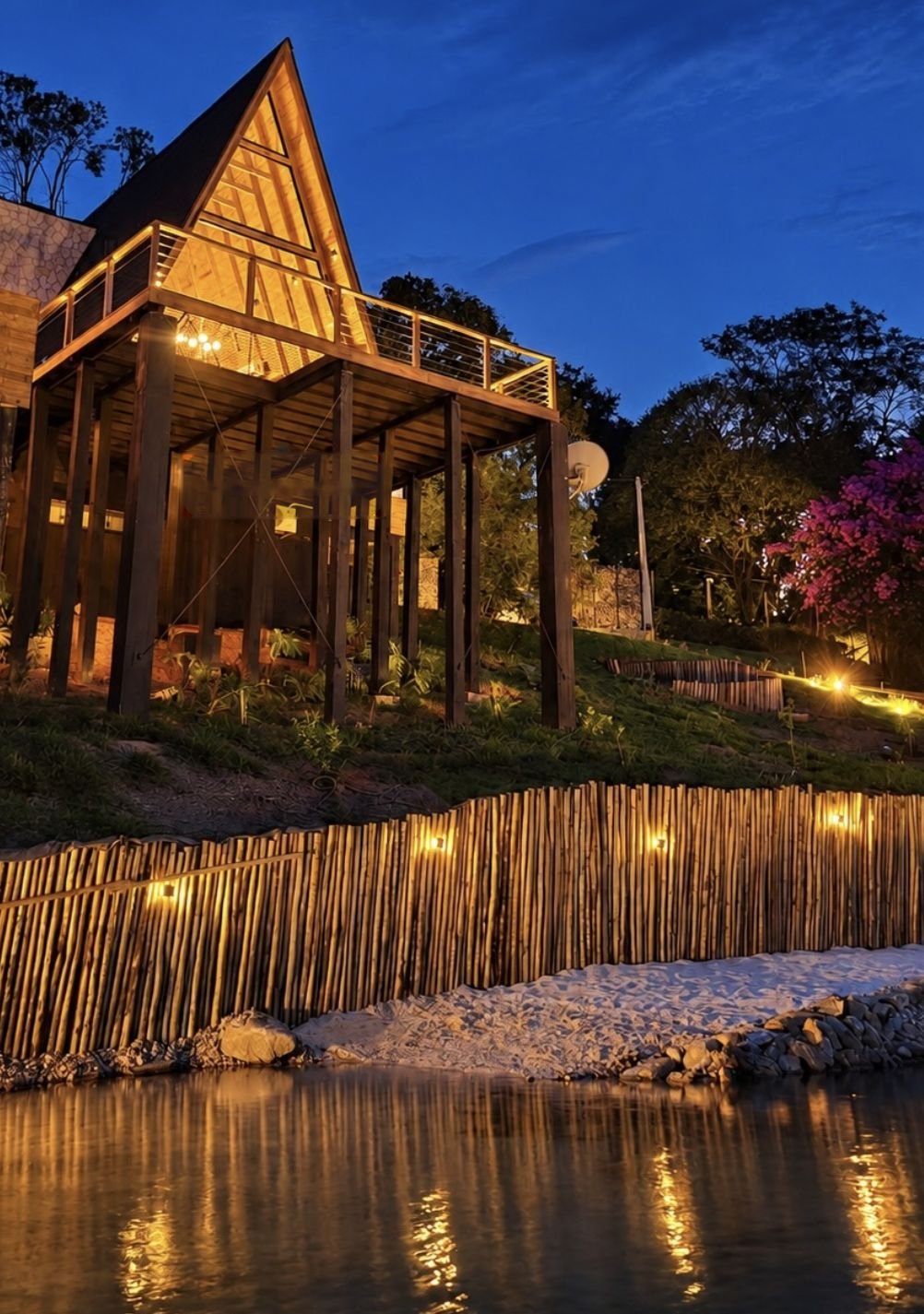 Cabana Yeshua iluminada à noite, refletida no lago azul