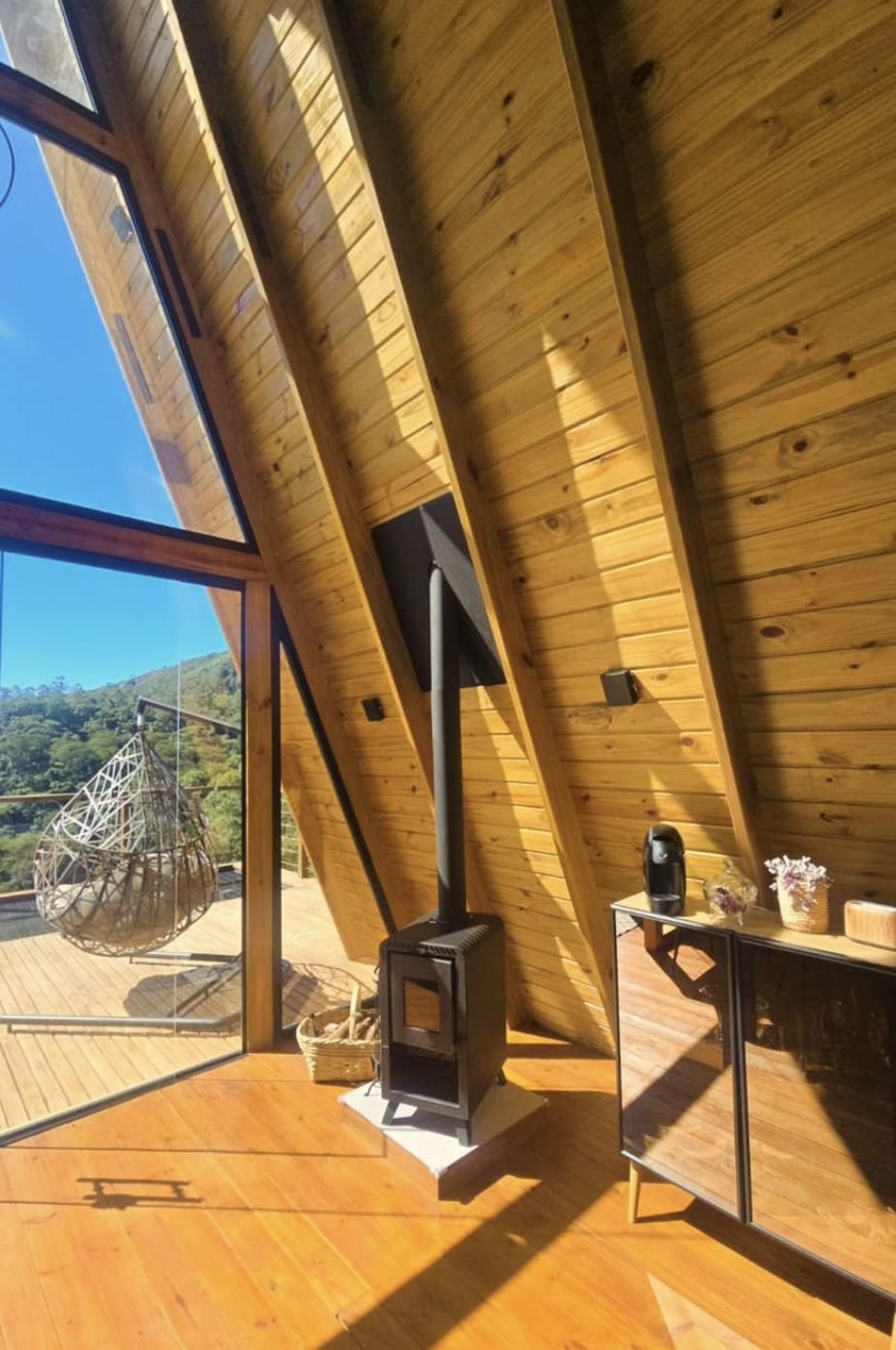 Calefator a lenha ao lado da porta de vidro para o deck